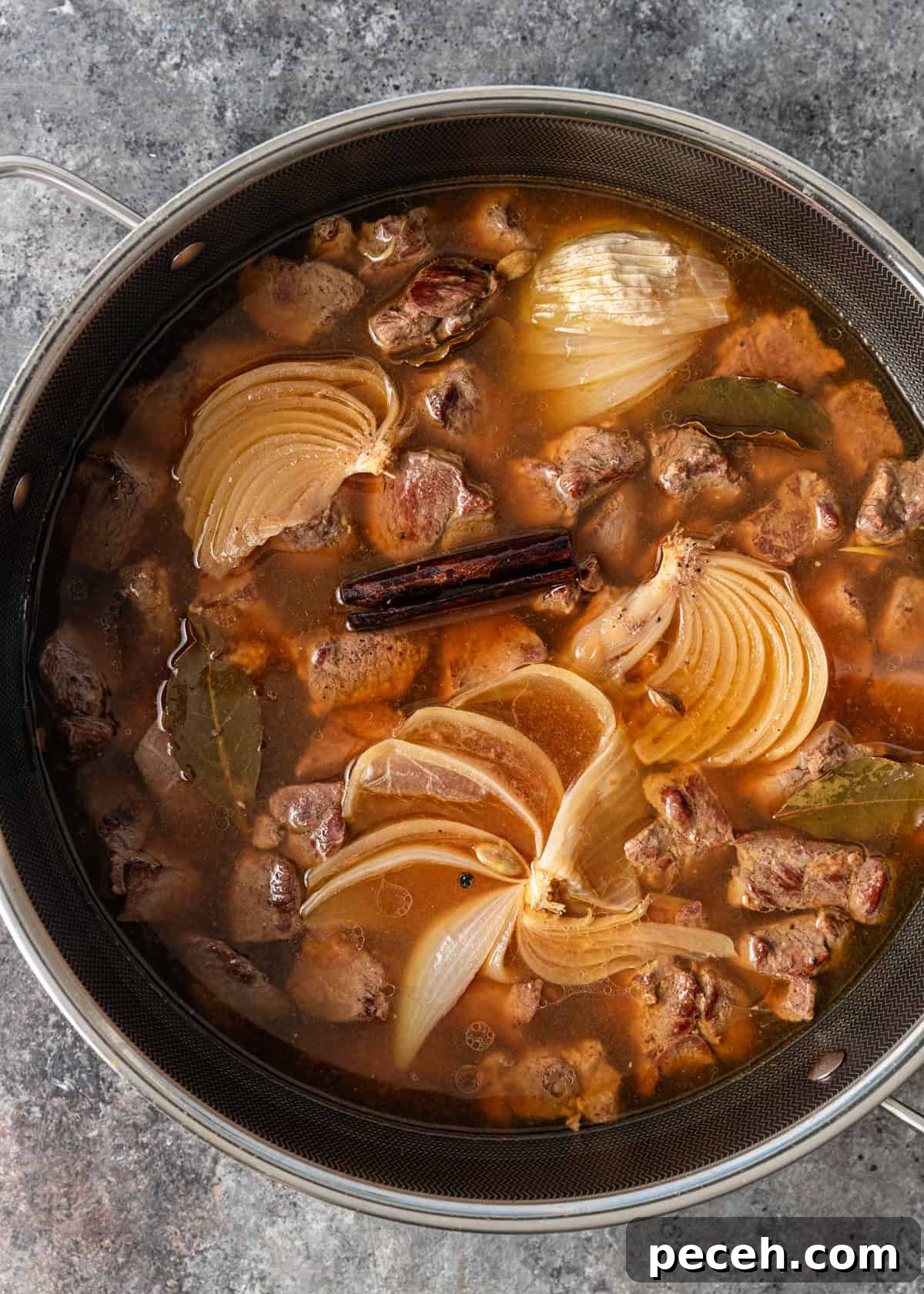 Authentic Jordanian Mansaf Recipe: Traditional Bedouin Feast 7 overhead process shot: soaked lamb in water, cardamom, bay leaves, cinnamon, peppercorns, and onion