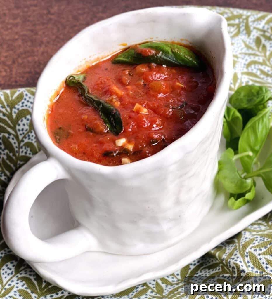 Authentic Meatless Sugo: Italian Tomato and Basil Sauce Recipe 10 Tomato basil sugo recipe in gravy boat with basil garnish.