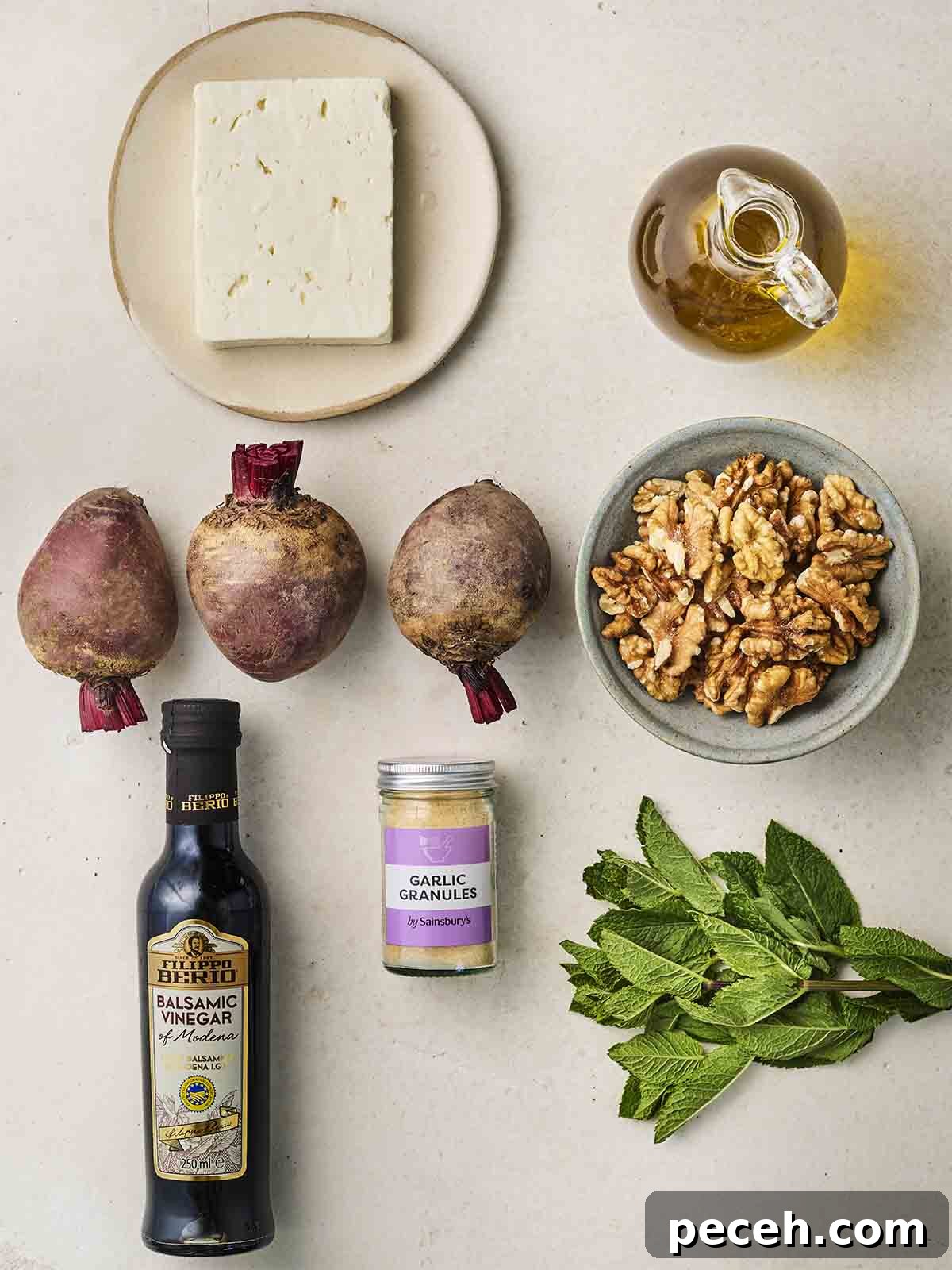 The ingredients for making a Beetroot Salad laid out on a white counter.