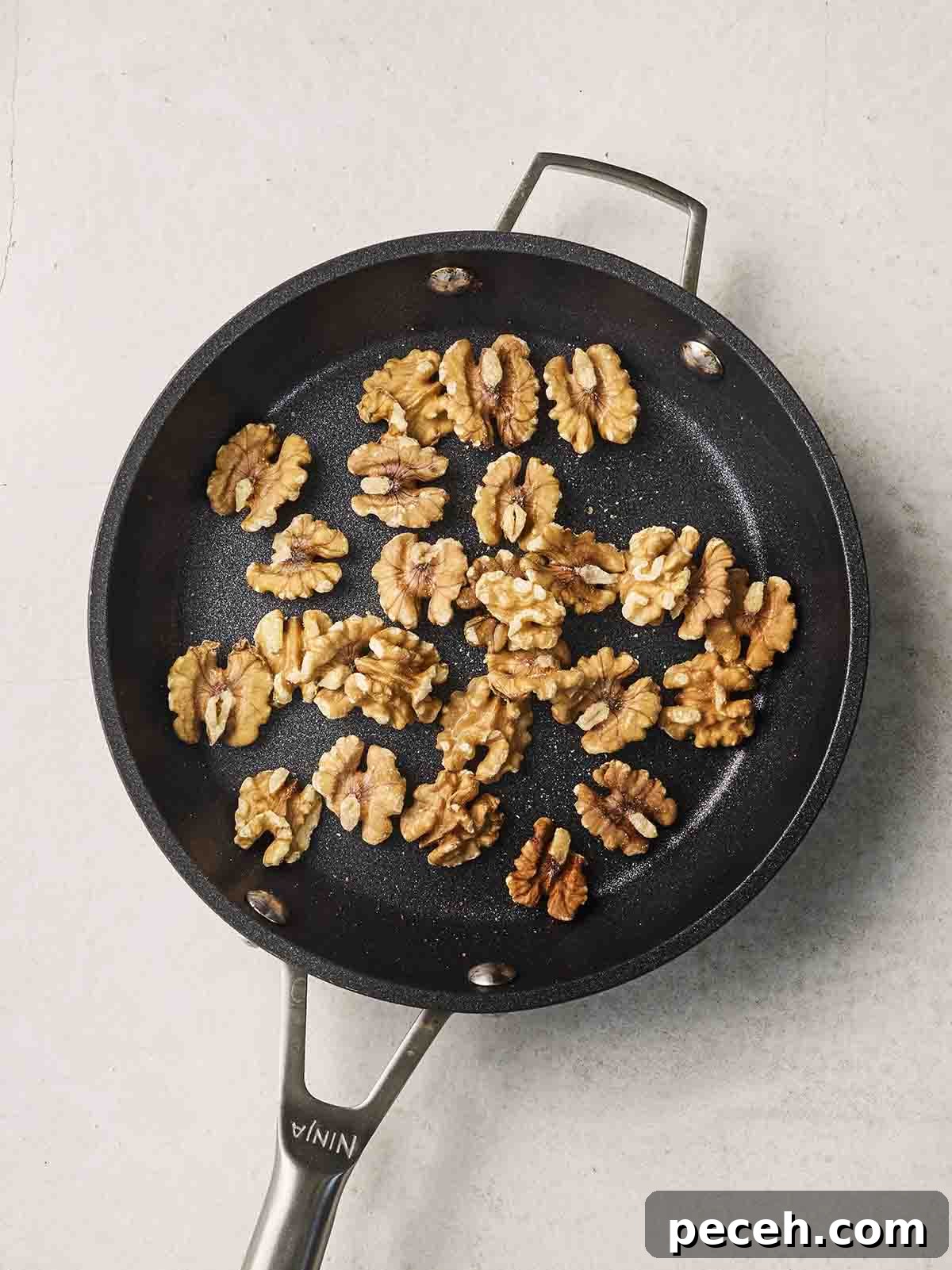 Walnuts toasting in a pan.