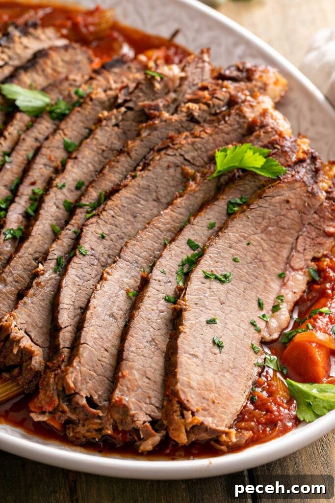 Thinly sliced beef brisket garnished with parsley on a bed of onions, carrots and a tomato based sauce.