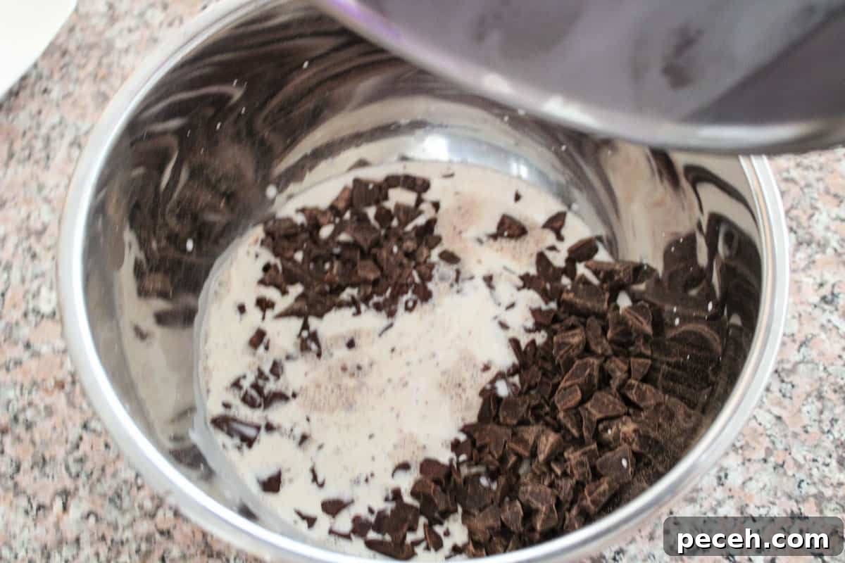Decadent Christmas Truffles: Festive Homemade Chocolate Treats 5 A stainless bowl with chocolate that hot heavy cream was just added to from a stainless pot, the last drips being poured in.