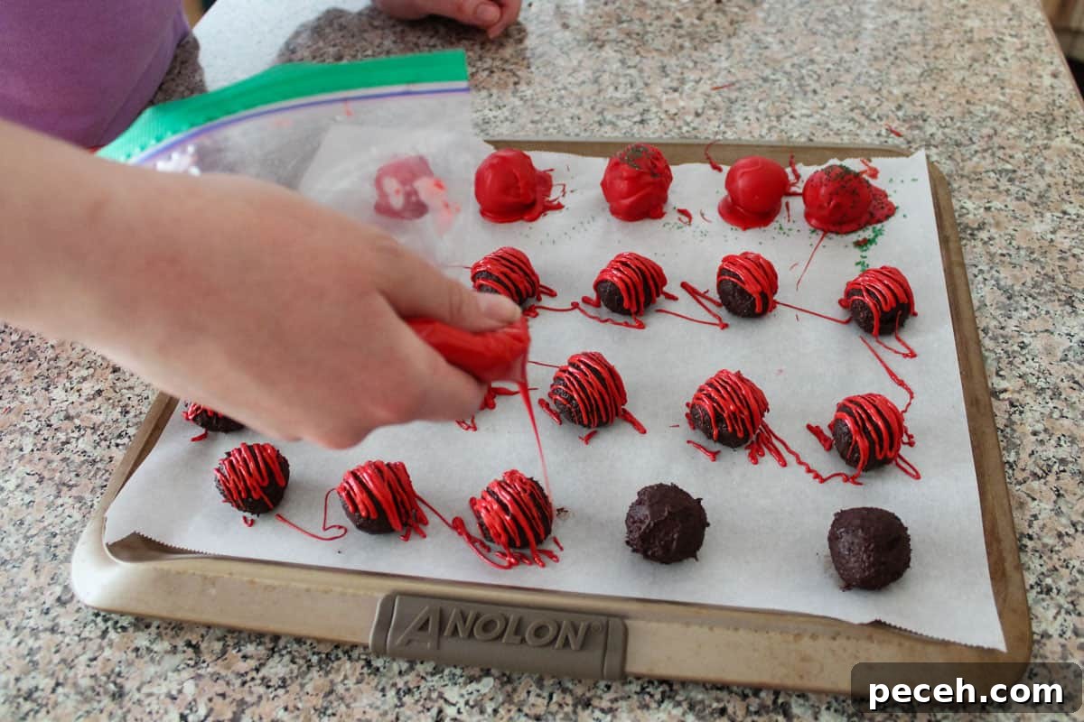 Decadent Christmas Truffles: Festive Homemade Chocolate Treats 9 Someone drizzling melted wafers in a zip-top bag over some truffles, while others were dipped.