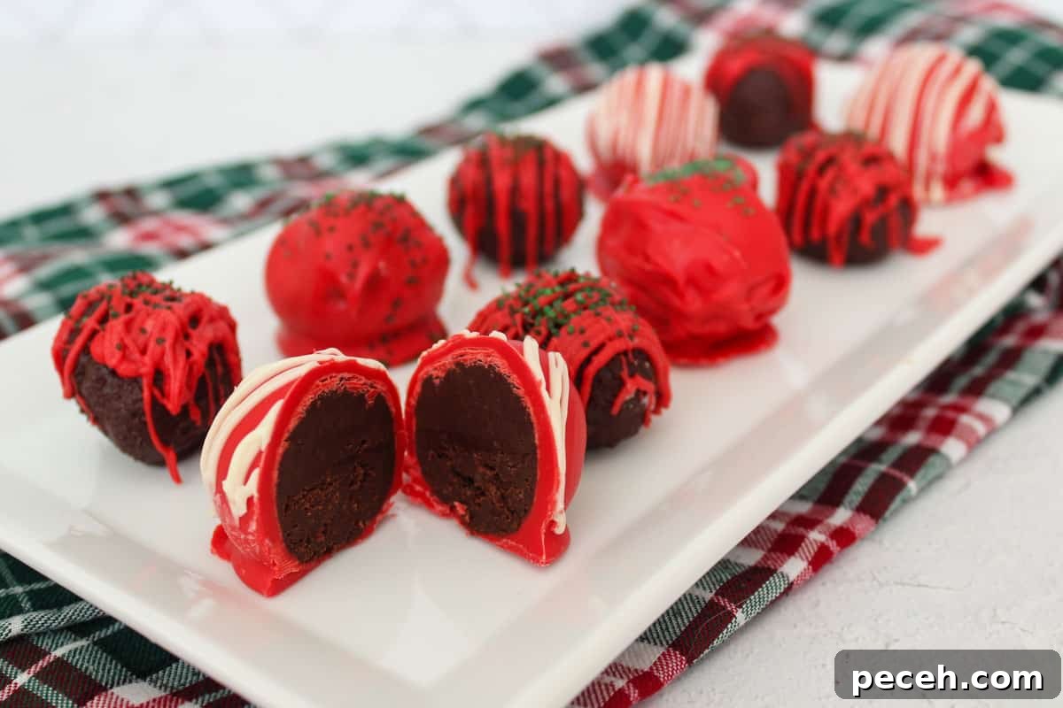 Decadent Christmas Truffles: Festive Homemade Chocolate Treats 10 Red, white, and green decorated chocolate truffles on a white serving platter, the front one cut open.