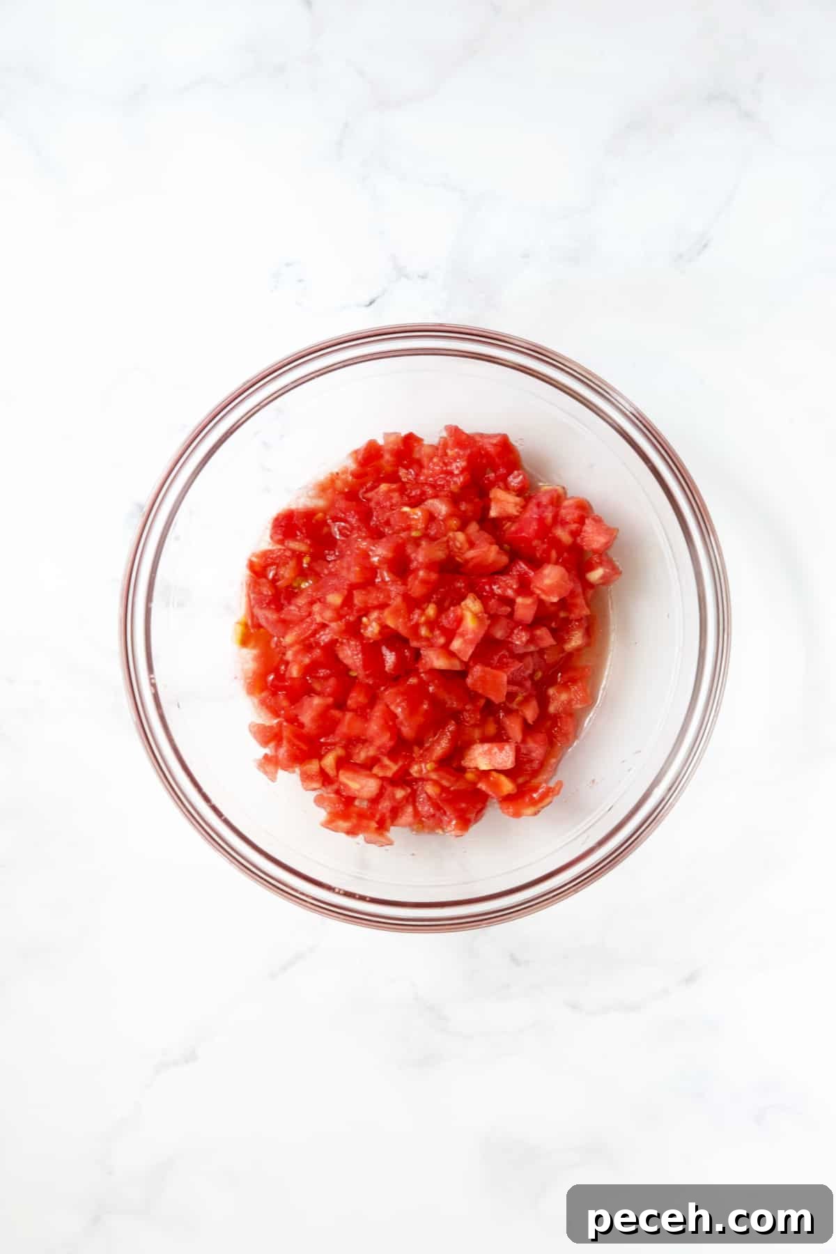 Diced tomatoes in glass bowl.