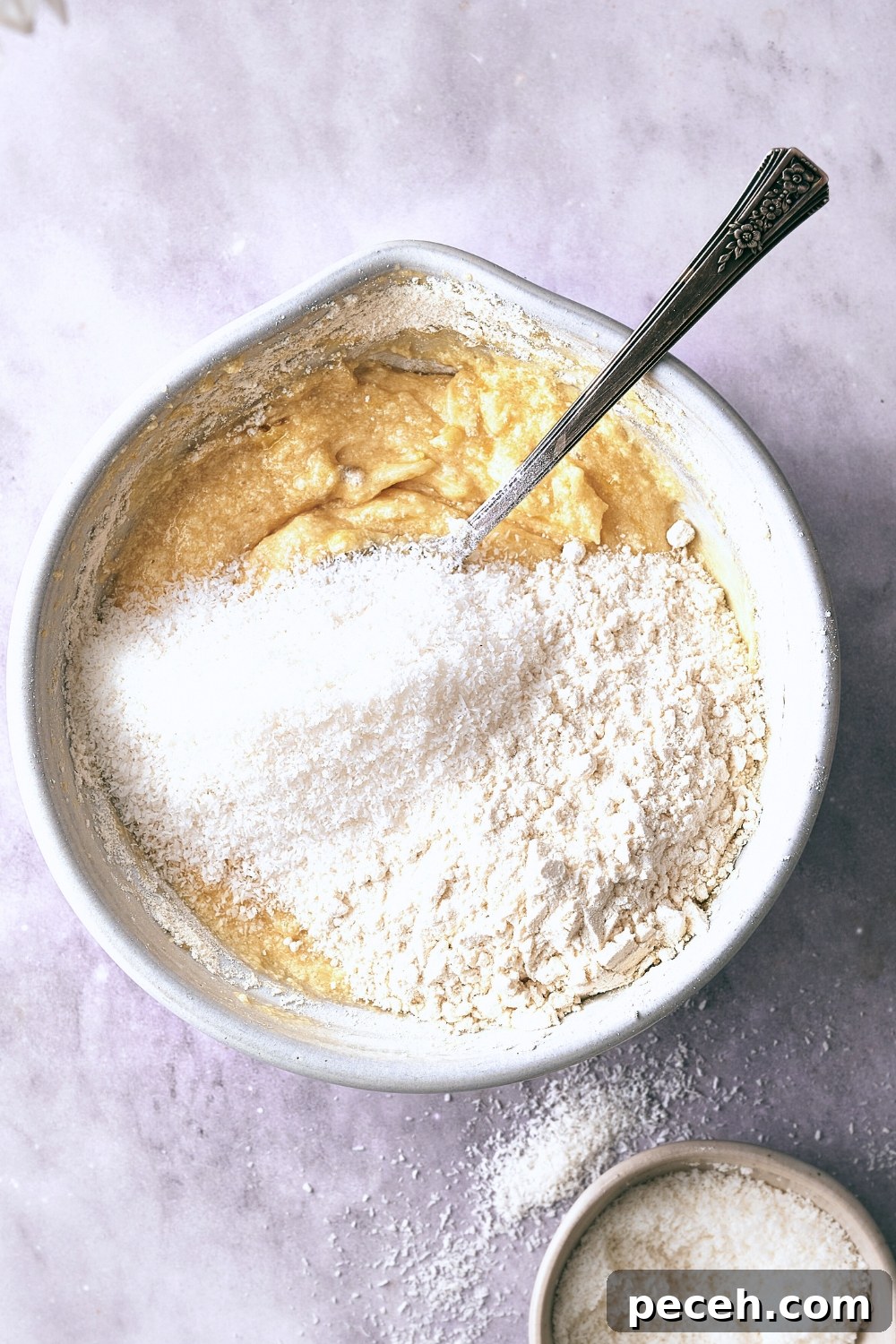 Tropical Hawaiian Banana Bread with Coconut and Macadamia Nuts 9 A mixing bowl with dry ingredients being added to the wet ingredients.