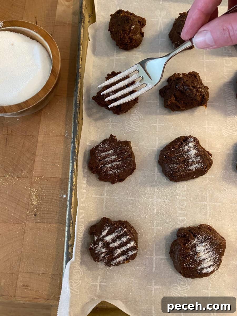 Chewy Vegan Molasses Snap Cookies 8 A fork with sugar over a baking pan of molasses snaps.