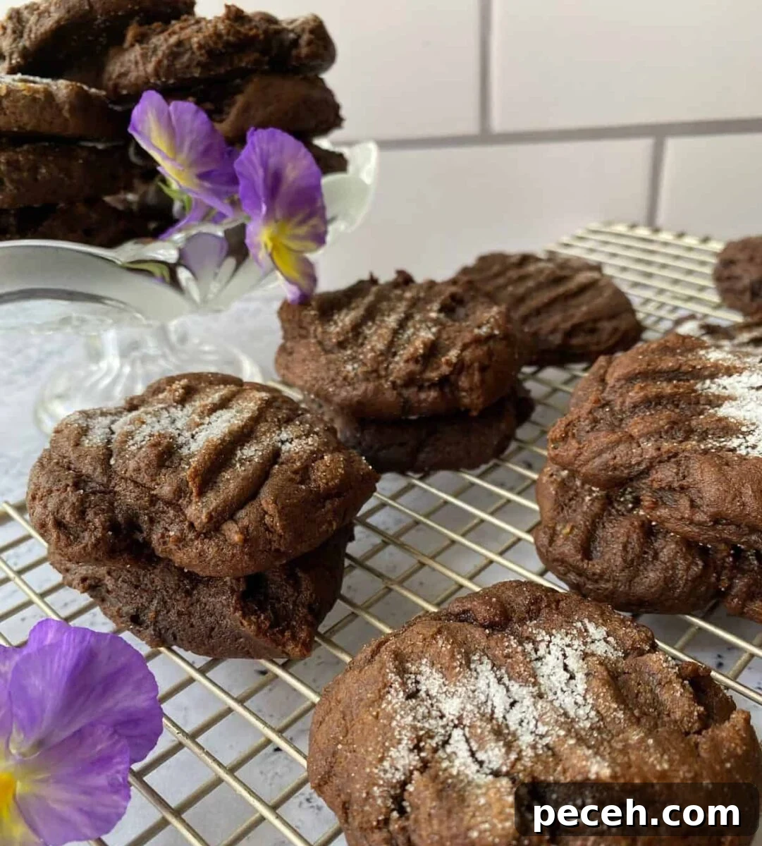 Chewy Vegan Molasses Snap Cookies 10 Snaps on a cooling rack with a pansy on the side.