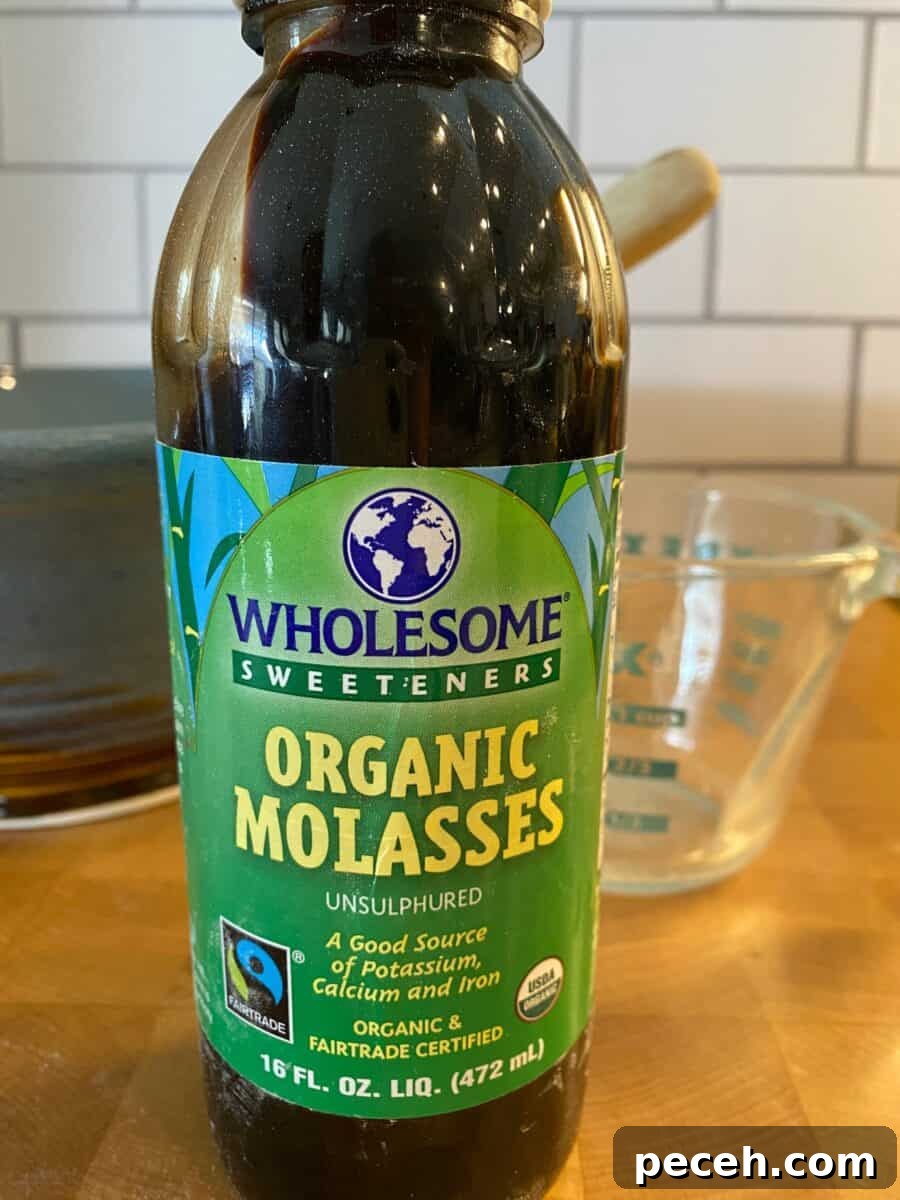 Chewy Vegan Molasses Snap Cookies 5 A jar of molasses on a counter.