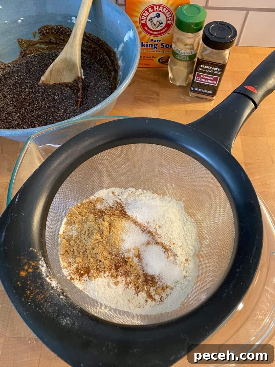 Chewy Vegan Molasses Snap Cookies 7 Dry ingredients in a whisk over a bowl, with containers of spices and another bowl off to the side.