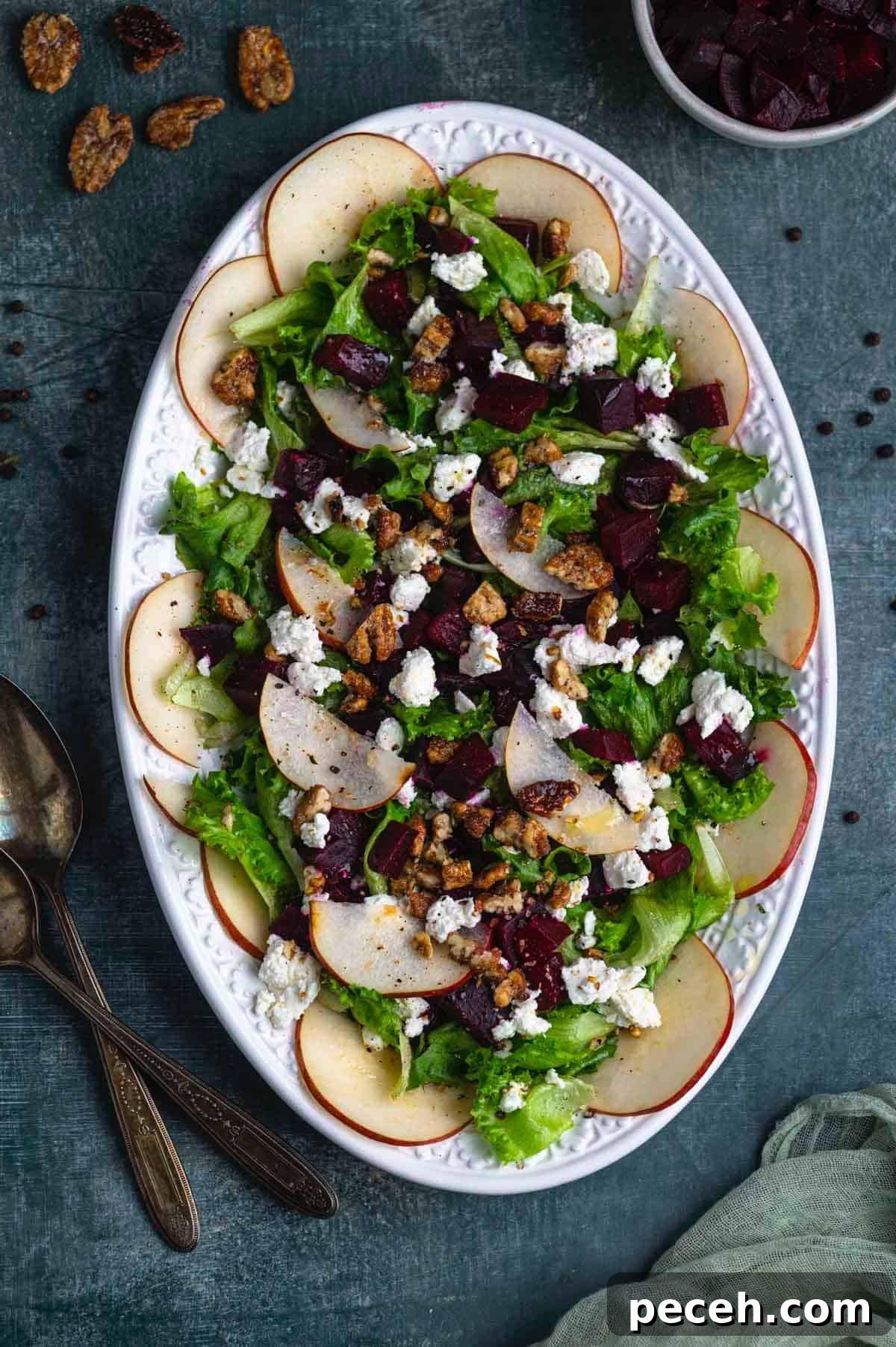 Roasted Beet Salad with Goat Cheese, Arugula and Walnuts 2 overhead image of a beet salad with goat cheese and pears on a white oval platter