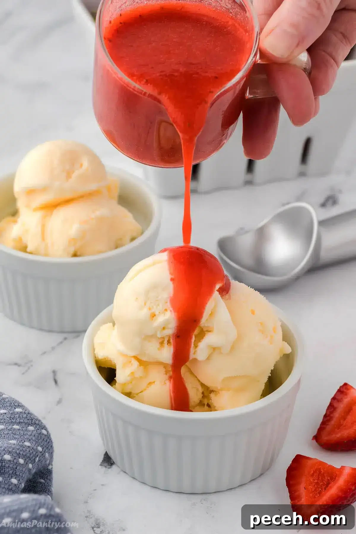 Silky Strawberry Coulis Recipe for Desserts and Drinks 2 A hand pouring some strawberry coulis on ice cream.