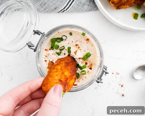 Chili Lime Chicken Wings with Tangy Dipping Sauce 12 Wing being dipped into sour cream sauce.