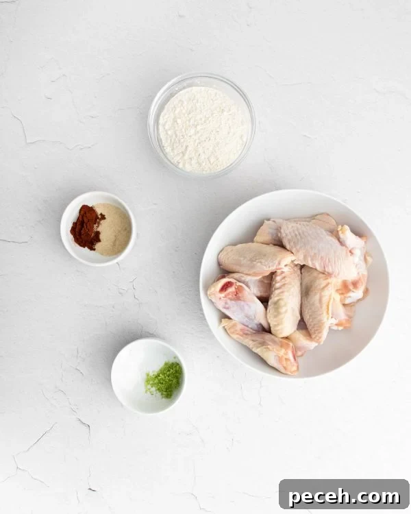 Chili Lime Chicken Wings with Tangy Dipping Sauce 7 Raw wings in a bowl, small bowls of other ingredients also visible.