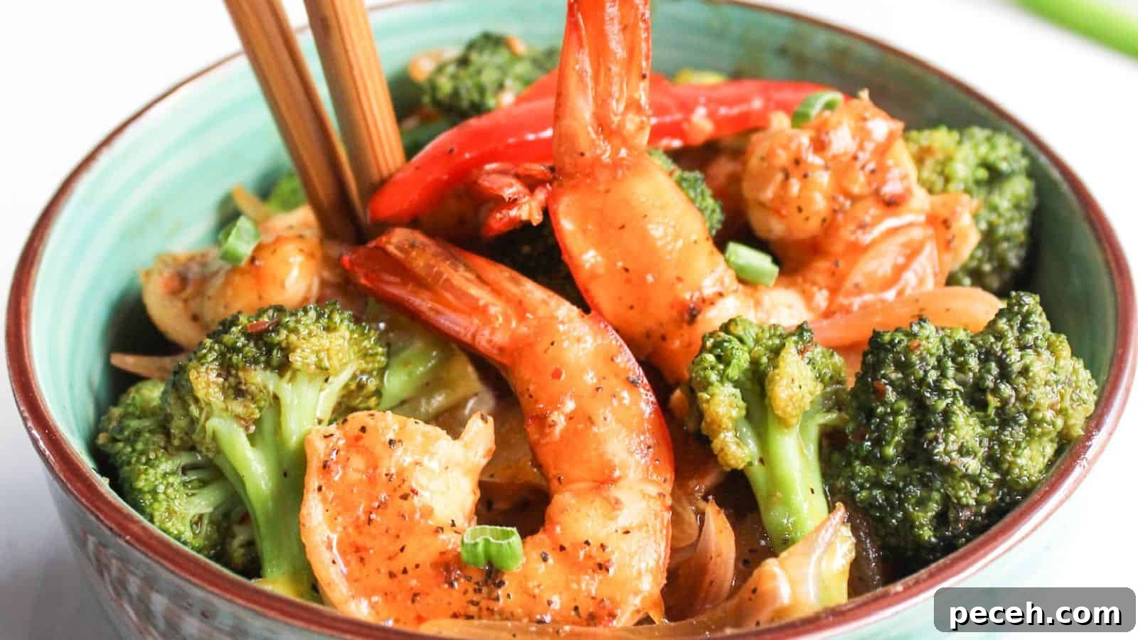 Bowl of stir-fried shrimp and broccoli with chopsticks.