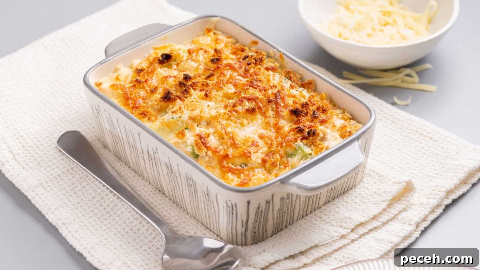 A casserole dish with cheese and broccoli on a napkin.