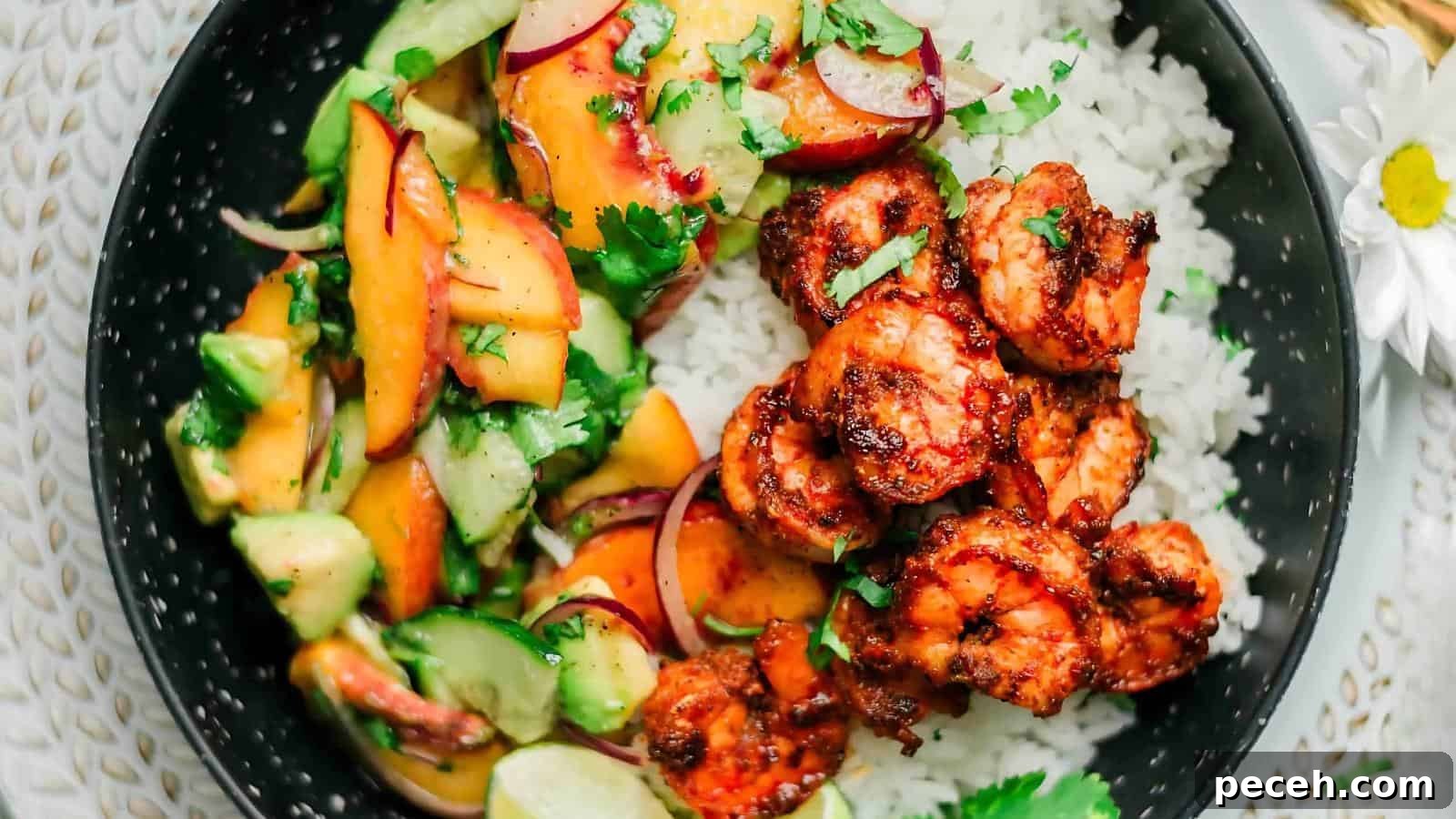 A dish with grilled shrimp on rice and a side of cucumber-peach salad with herbs, garnished with cilantro.