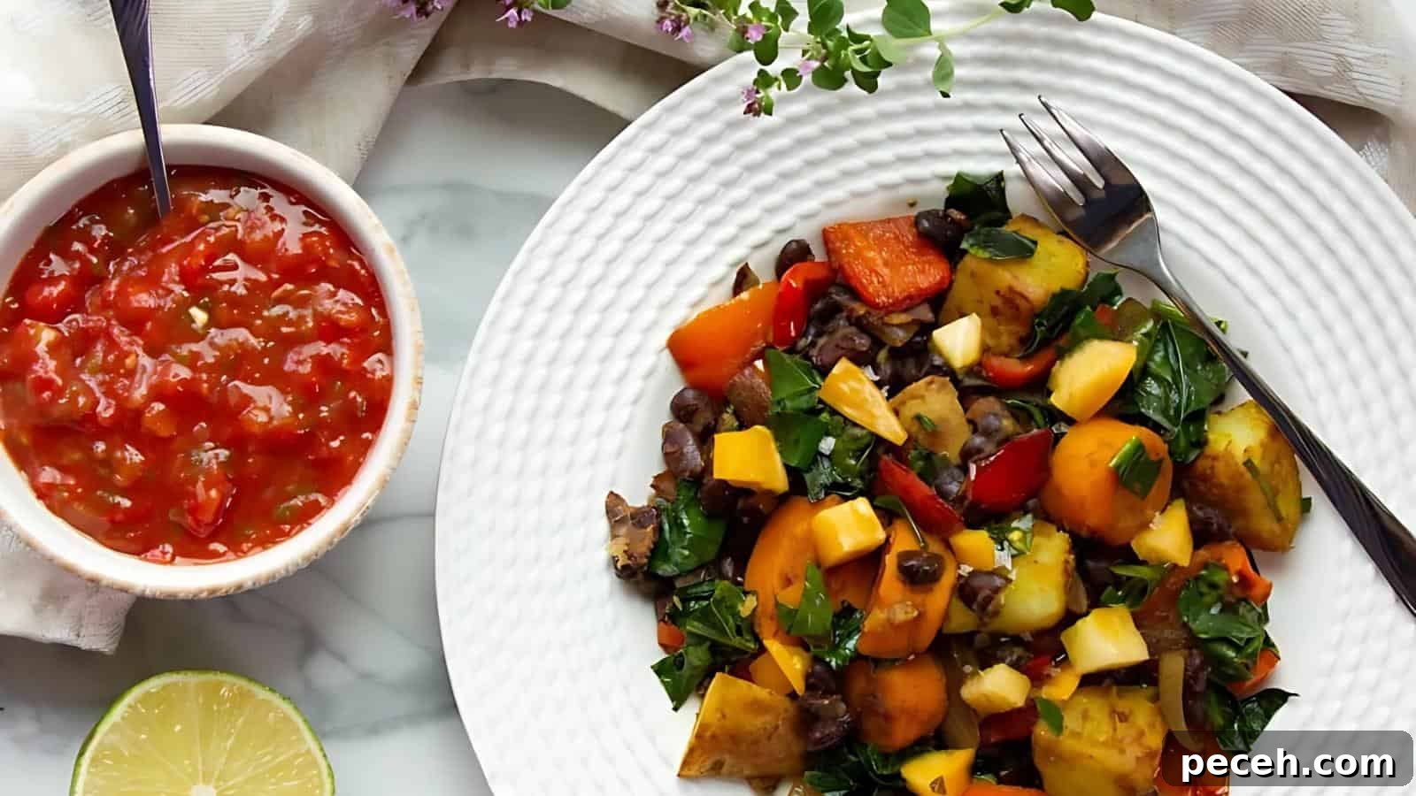A plate of mixed vegetables and greens next to a bowl of chunky tomato salsa, with a lime wedge nearby on a marble surface.