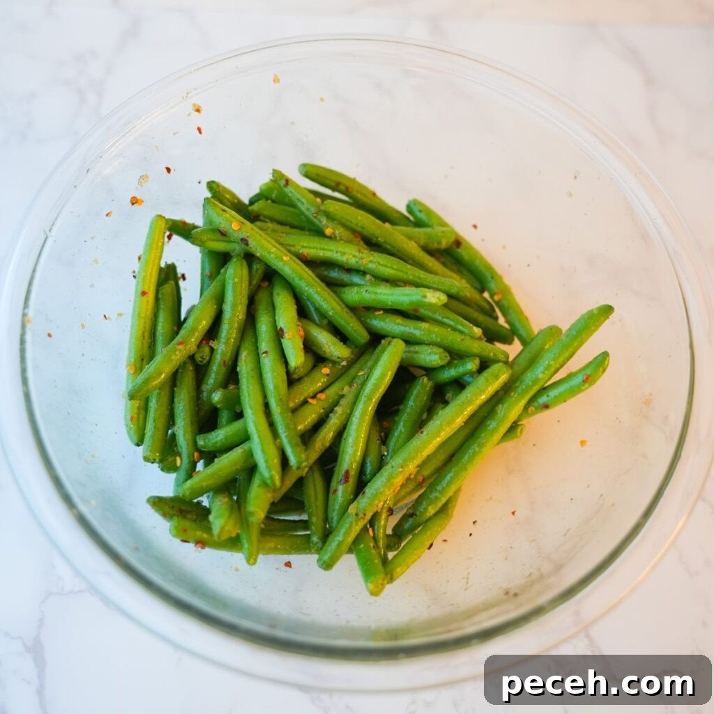 Green beans in a glass bowl with seasonings.