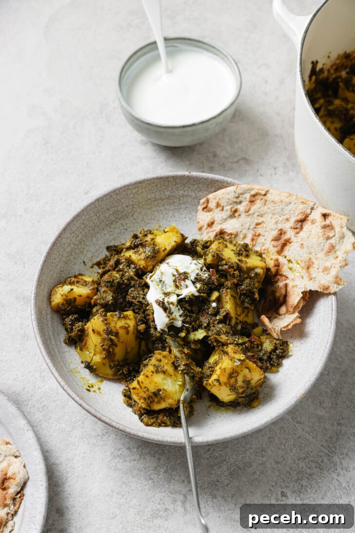 Authentic Aloo Methi (Potato & Fenugreek Leaves) Recipe from Mom-in-Law 15 Partially eaten Aloo Methi in a plate with a dollop of yogurt and naan on the side.