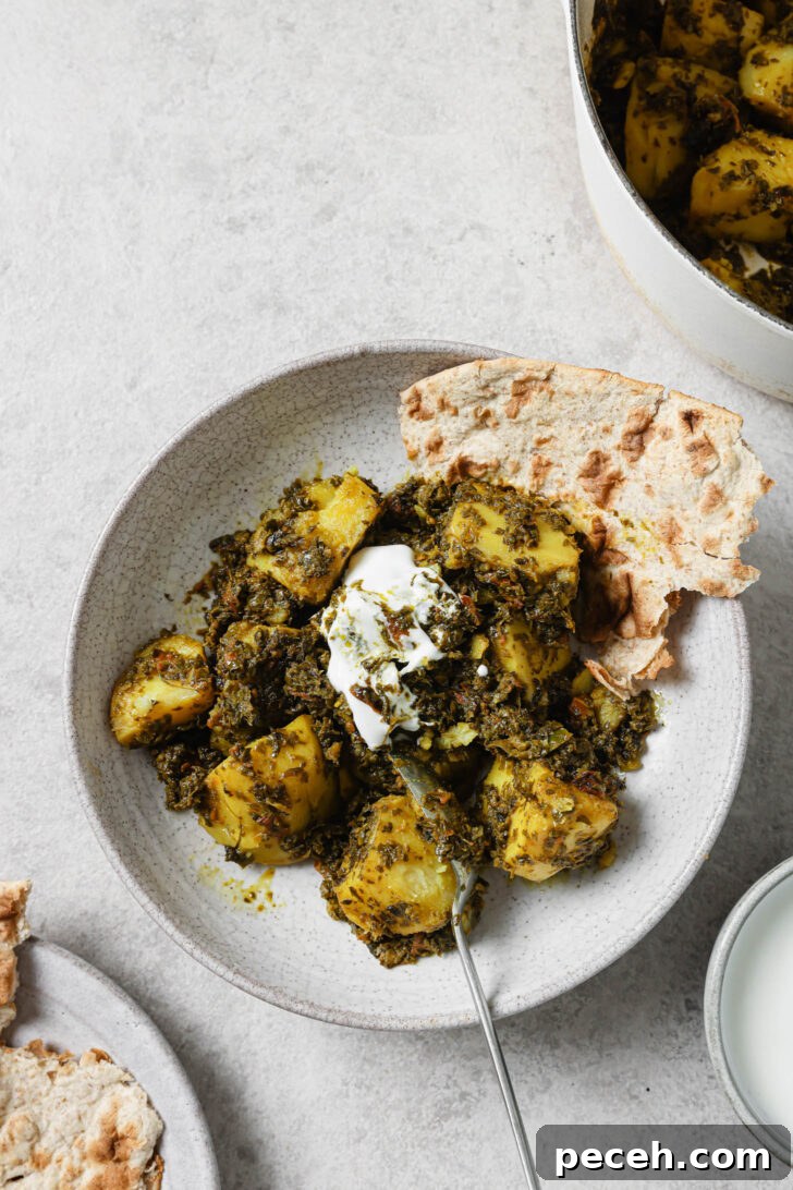 Authentic Aloo Methi (Potato & Fenugreek Leaves) Recipe from Mom-in-Law 16 Partially eaten Aloo Methi in a plate with a dollop of yogurt and naan on the side.