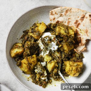 Authentic Aloo Methi (Potato & Fenugreek Leaves) Recipe from Mom-in-Law 17 Partially eaten Aloo Methi in a plate with a dollop of yogurt and naan on the side.