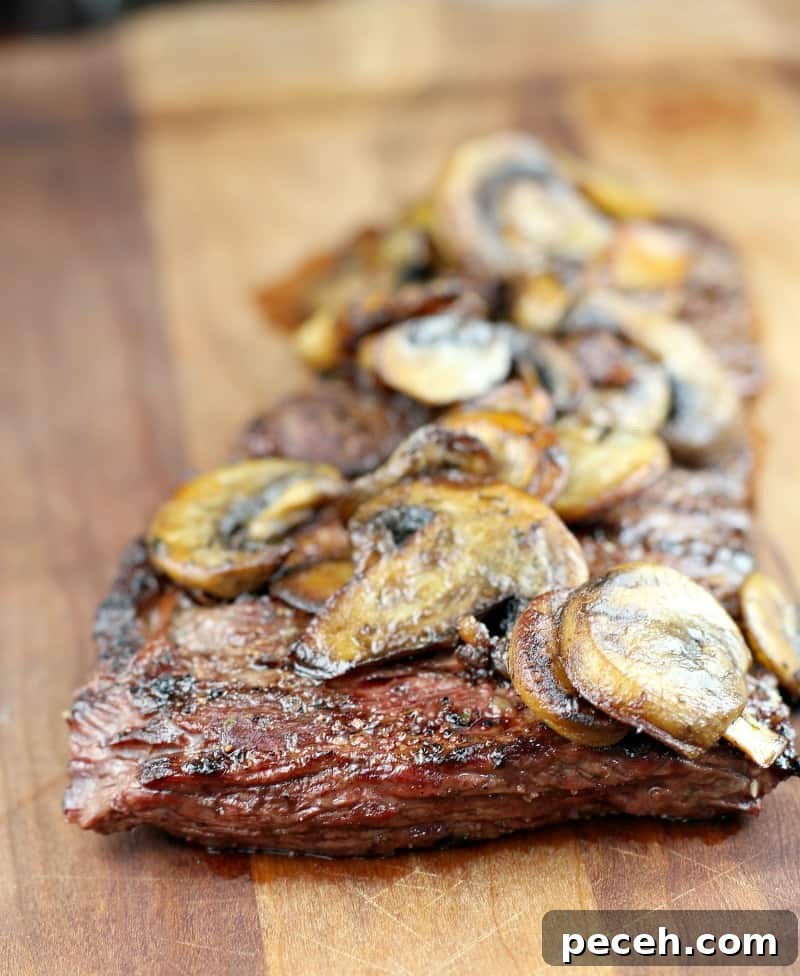 Garlic Butter Skirt Steak with Mushrooms — Bistro-Style Recipe 4 garlic butter skirt steak topped with mushrooms on a wood board