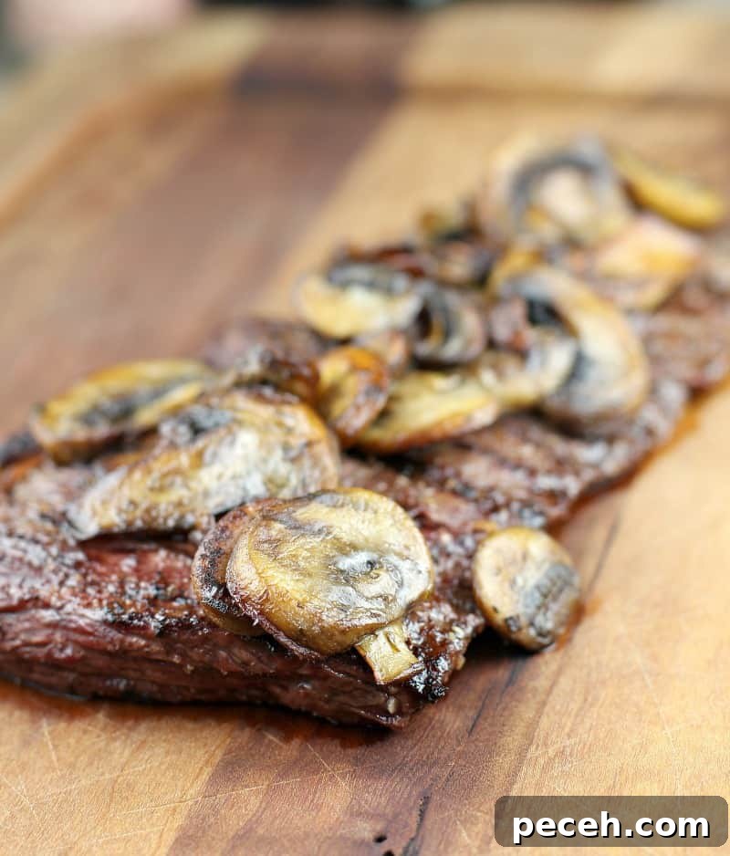 Garlic Butter Skirt Steak with Mushrooms — Bistro-Style Recipe 6 side view of steak on board topped with mushrooms