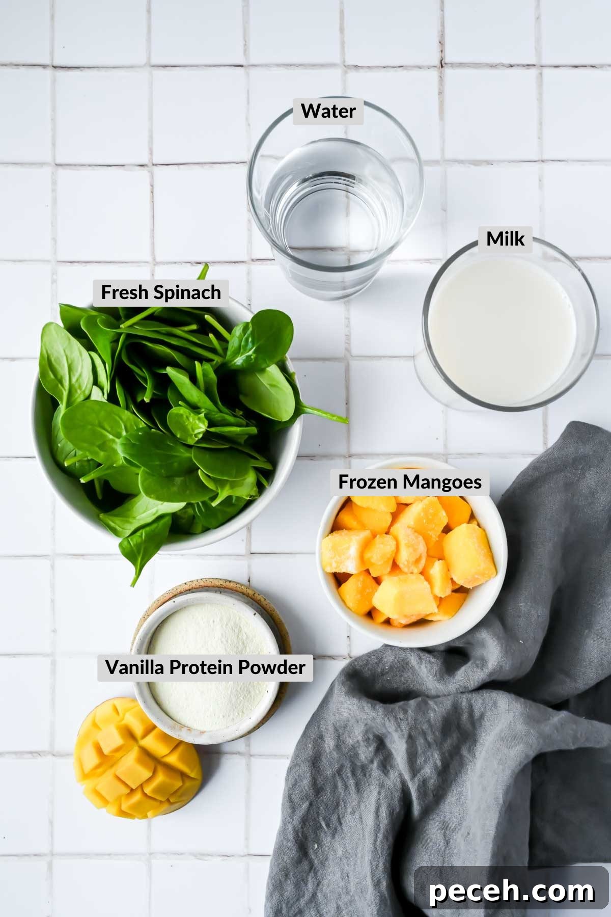 Mango Spinach Smoothie Recipe for Energy and Glow 3 ingredients for mango spinach protein smoothie in individual bowls on white tiled background.