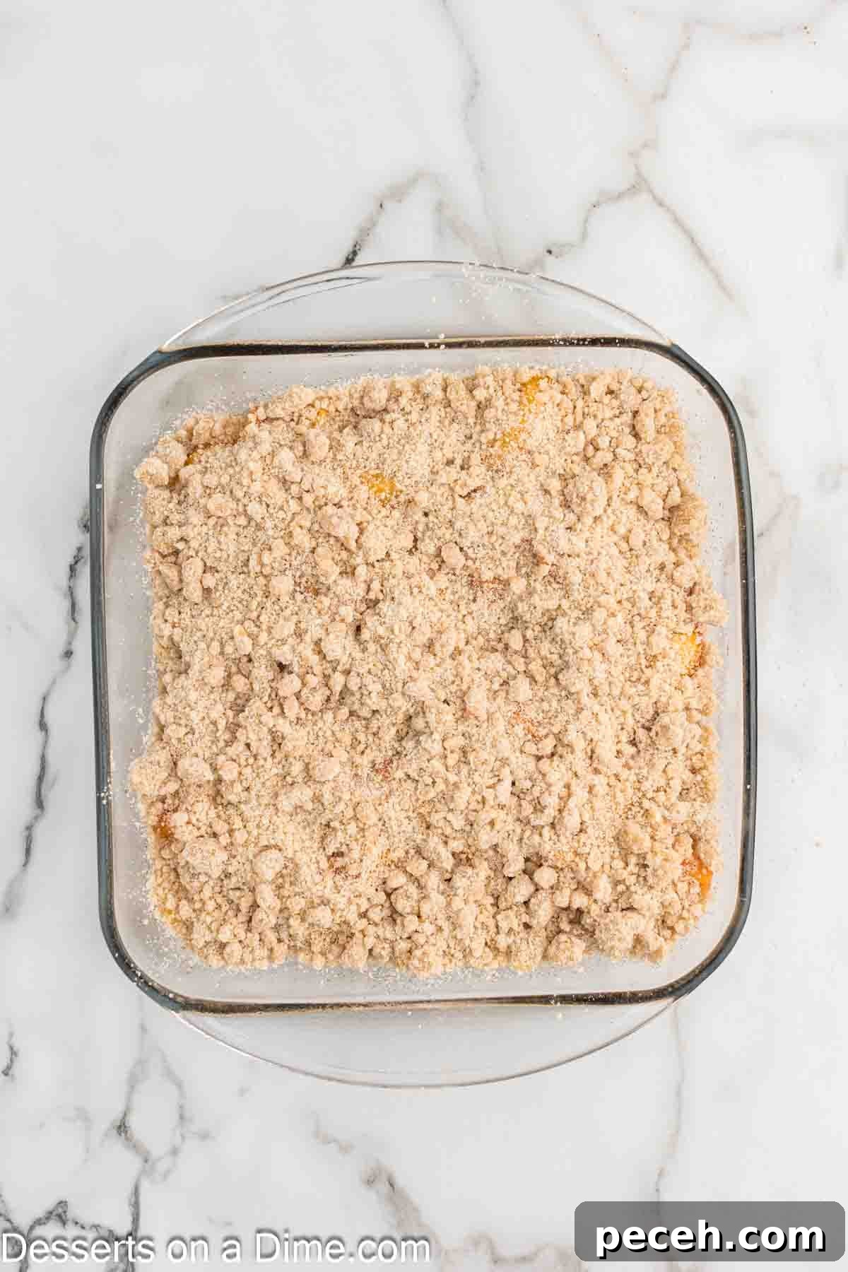 Perfect Peach Crumble Recipe for Summer Desserts 7 Crumble spread on top of dish.
