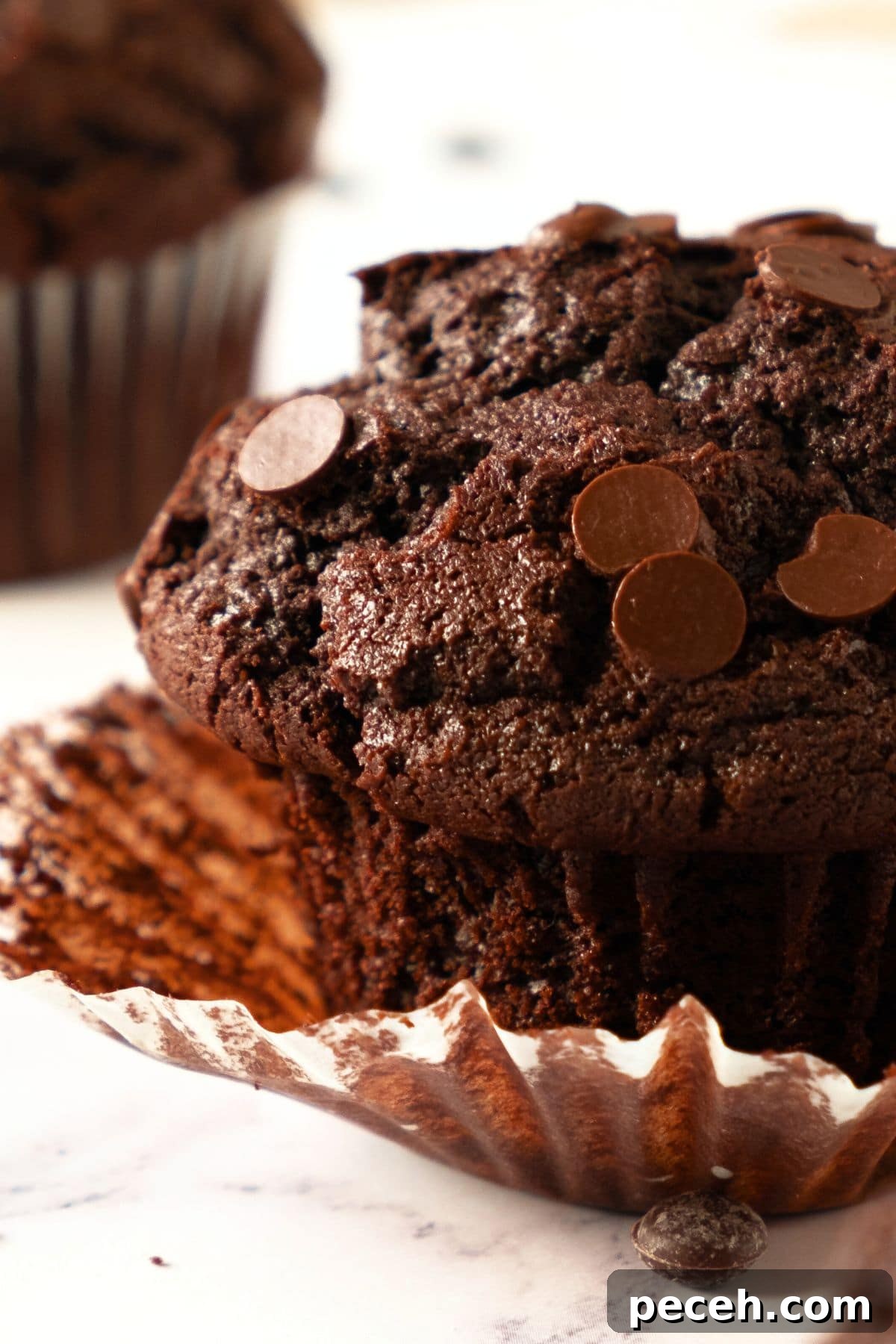 Easy Gluten-Free Chocolate Muffins Up close view of a gf chocolate muffin and paper liner.