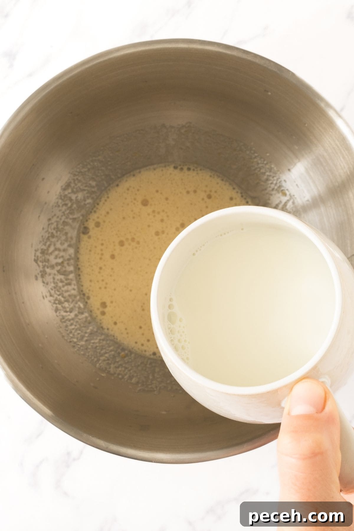 Double Chocolate Muffins with Chocolate Chips Pouring milk into a bowl of pale yellow mixture