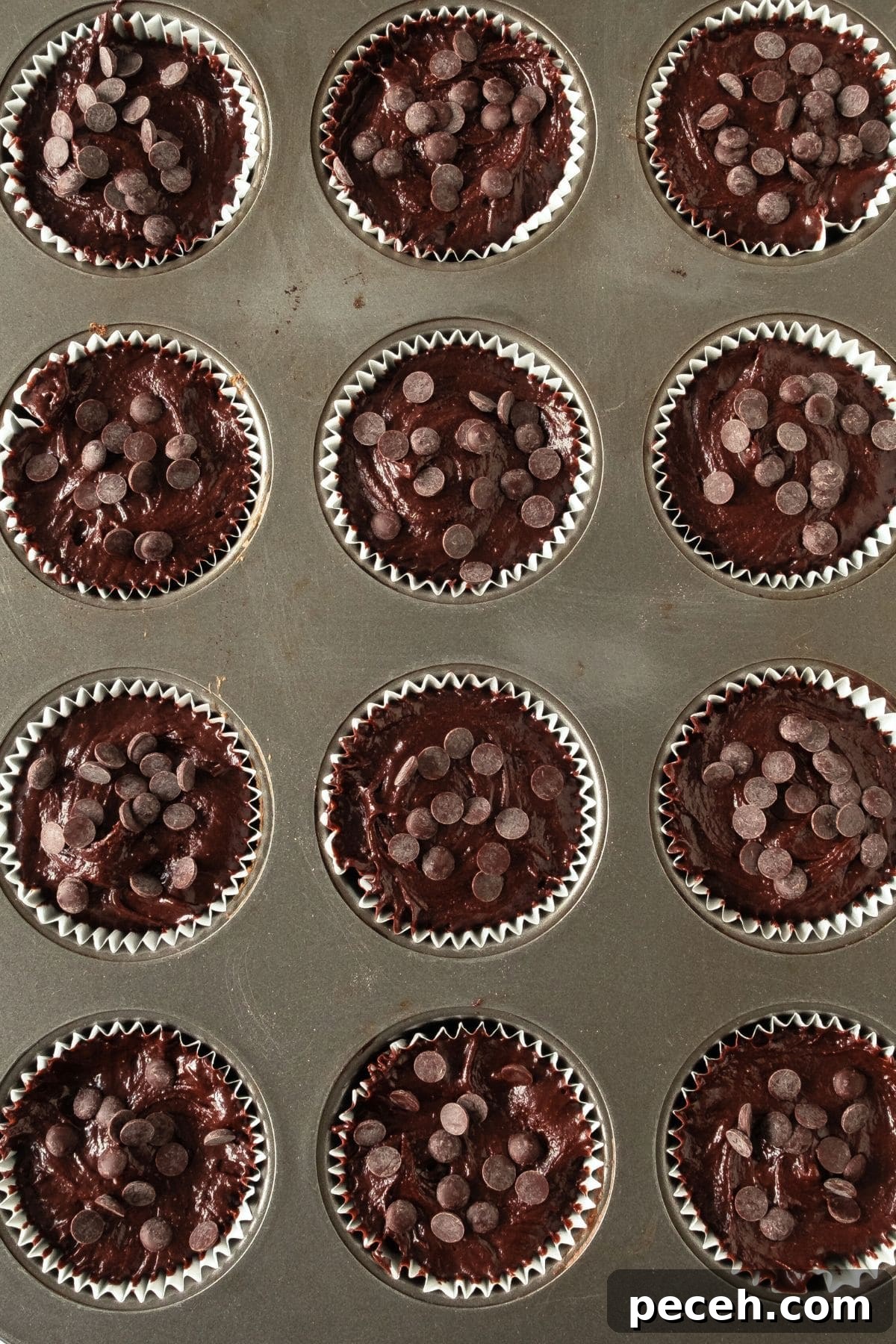 Easy Chocolate Muffins (Gluten-Free, Dairy-Free Option) Chocolate muffin batter in lined muffin pan topped with chocolate chips