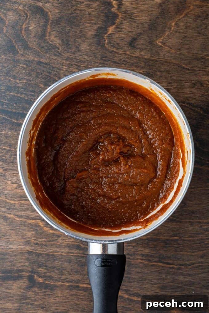 Classic Homemade Pumpkin Pie: Simple Recipe for Perfect Fall Dessert 5 pumpkin puree in a saucepan sitting on a wood surface