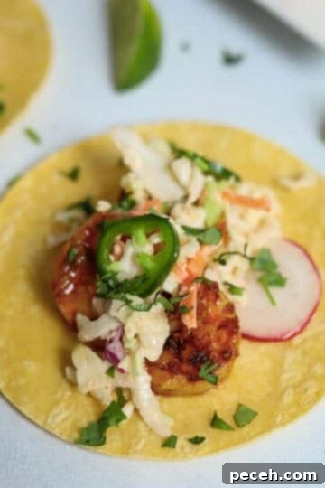 corn tortilla laid out and topped with shrimp, slaw, reddish, jalapeno
