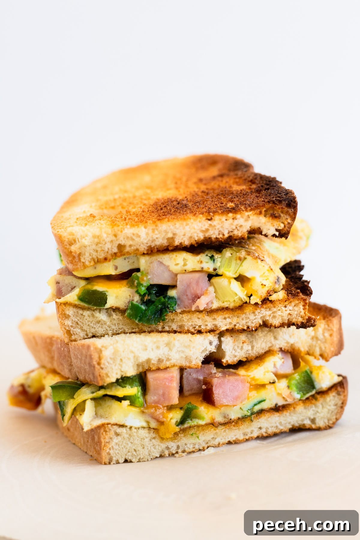 Classic Western Omelette Sandwich Recipe: How to Make It at Home 2 Two halves of a toasted western sandwich stacked on top of each other.