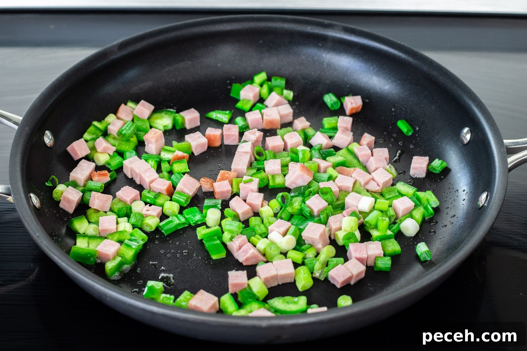 Classic Western Omelette Sandwich Recipe: How to Make It at Home 4 Ham, onion and green pepper sautéing in a skillet.