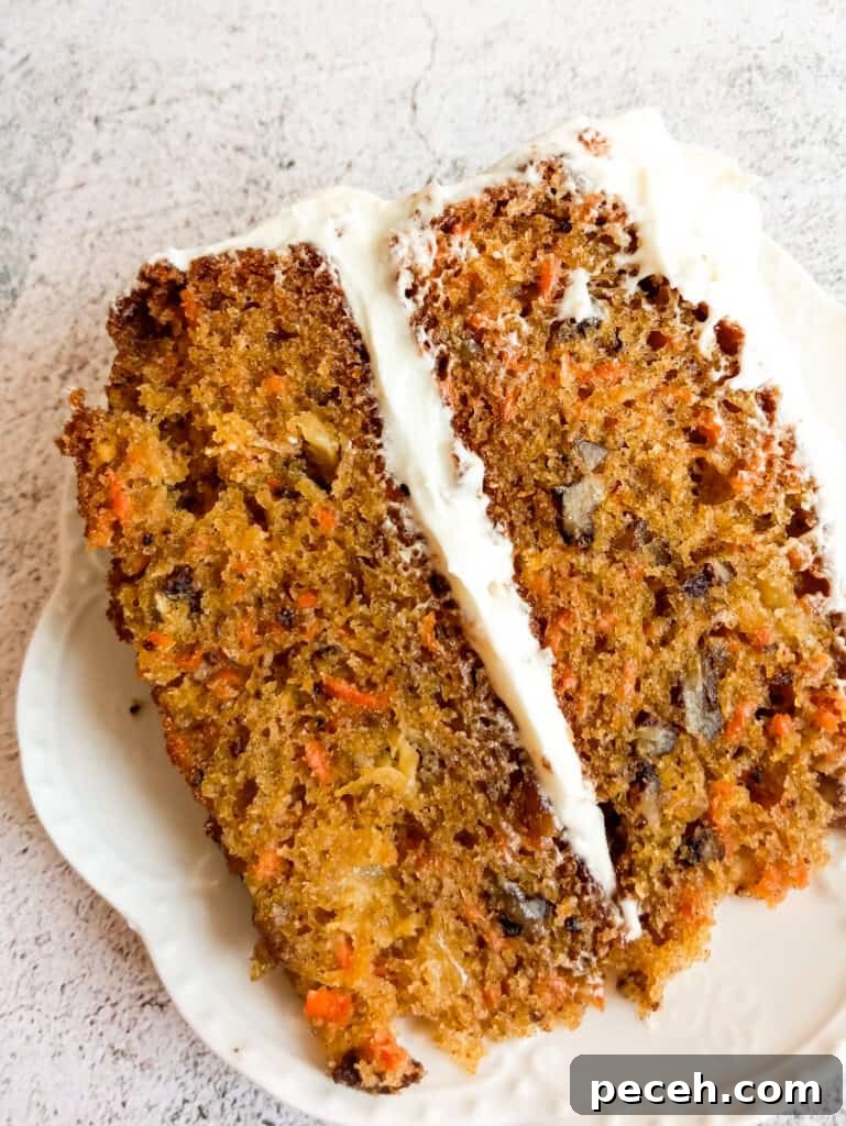 Amish Pineapple Carrot Cake with Pecans – Traditional Recipe 9 close up photo of a slice of layered carrot cake with cream cheese frosting.