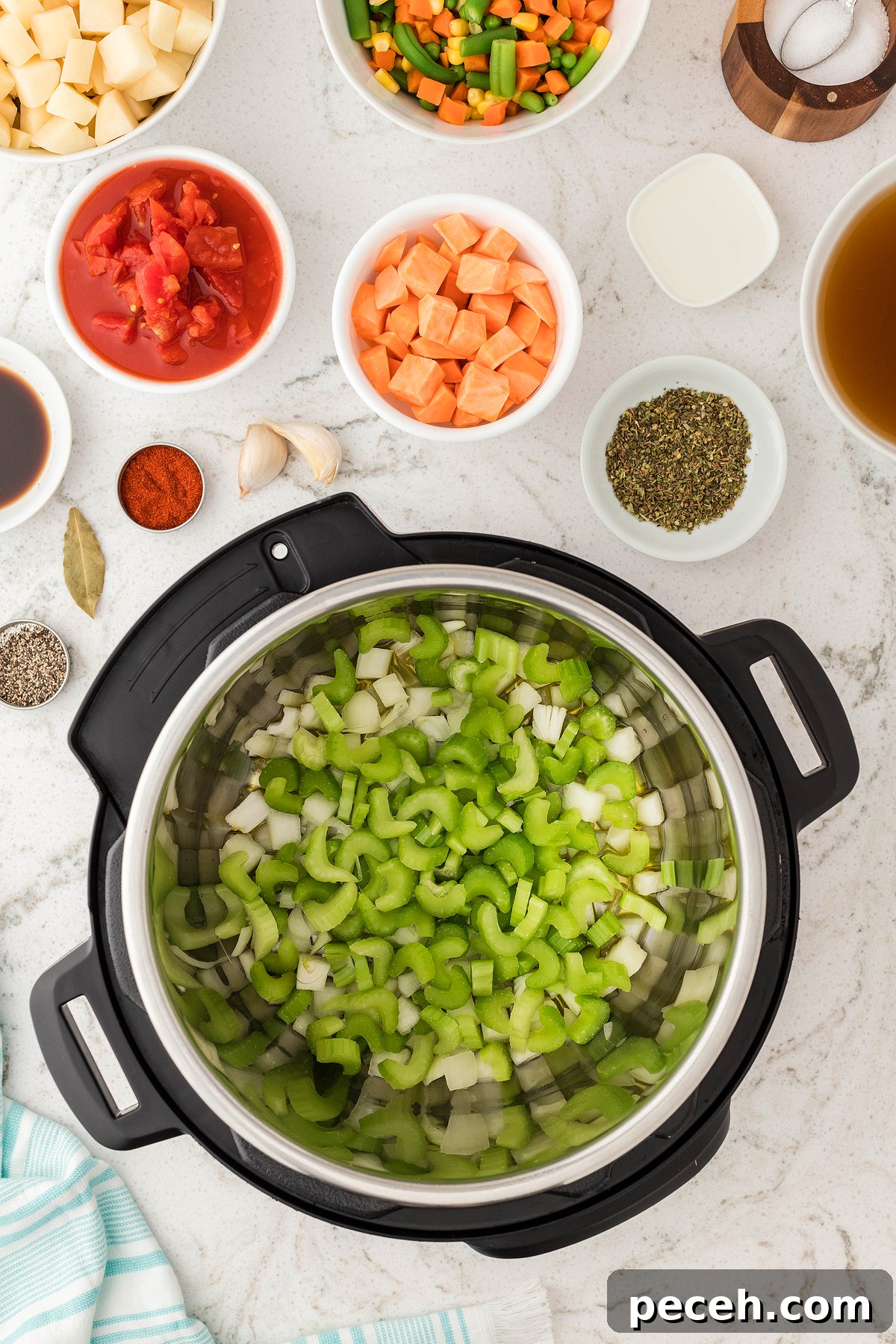 Chopped celery and onion in an Instant Pot, surrounded by bowls of vegetables, spices, and broth—perfect for making a hearty Instant Pot Vegetable Soup or your favorite vegetarian soup recipe.