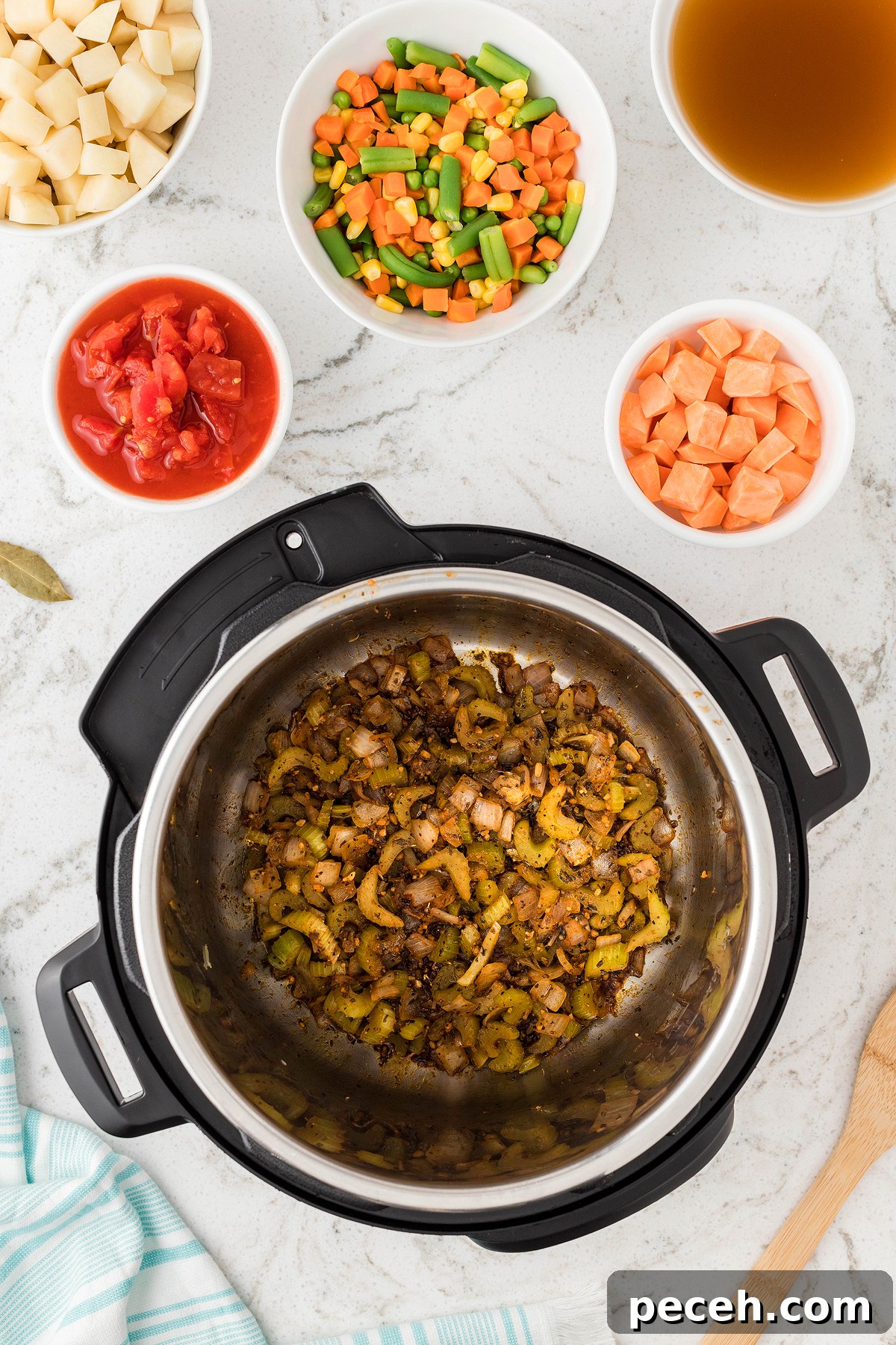 Top view of sautéed onions and celery in an Instant Pot, surrounded by bowls of broth and chopped vegetables—perfect for a quick 30 Minute Meal or as the base for an easy Instant Pot Vegetable Soup.