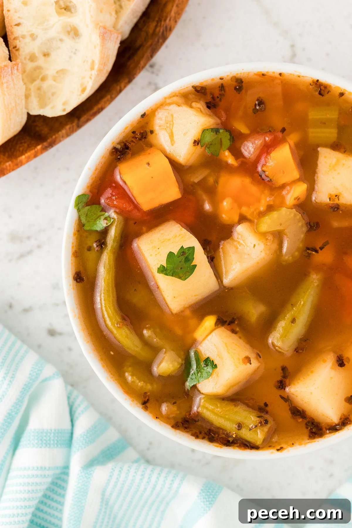 A bowl of Instant Pot Vegetable Soup with bread on the side, photographed from above on a white surface—an easy and delicious 30 Minute Meal.
