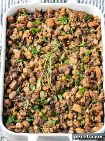 Finished dish of vegan stuffing with mushrooms in a white baking dish.