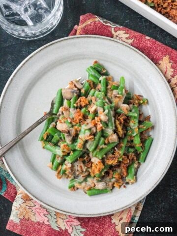 Serving of vegan green bean casserole on a plate with a fork.