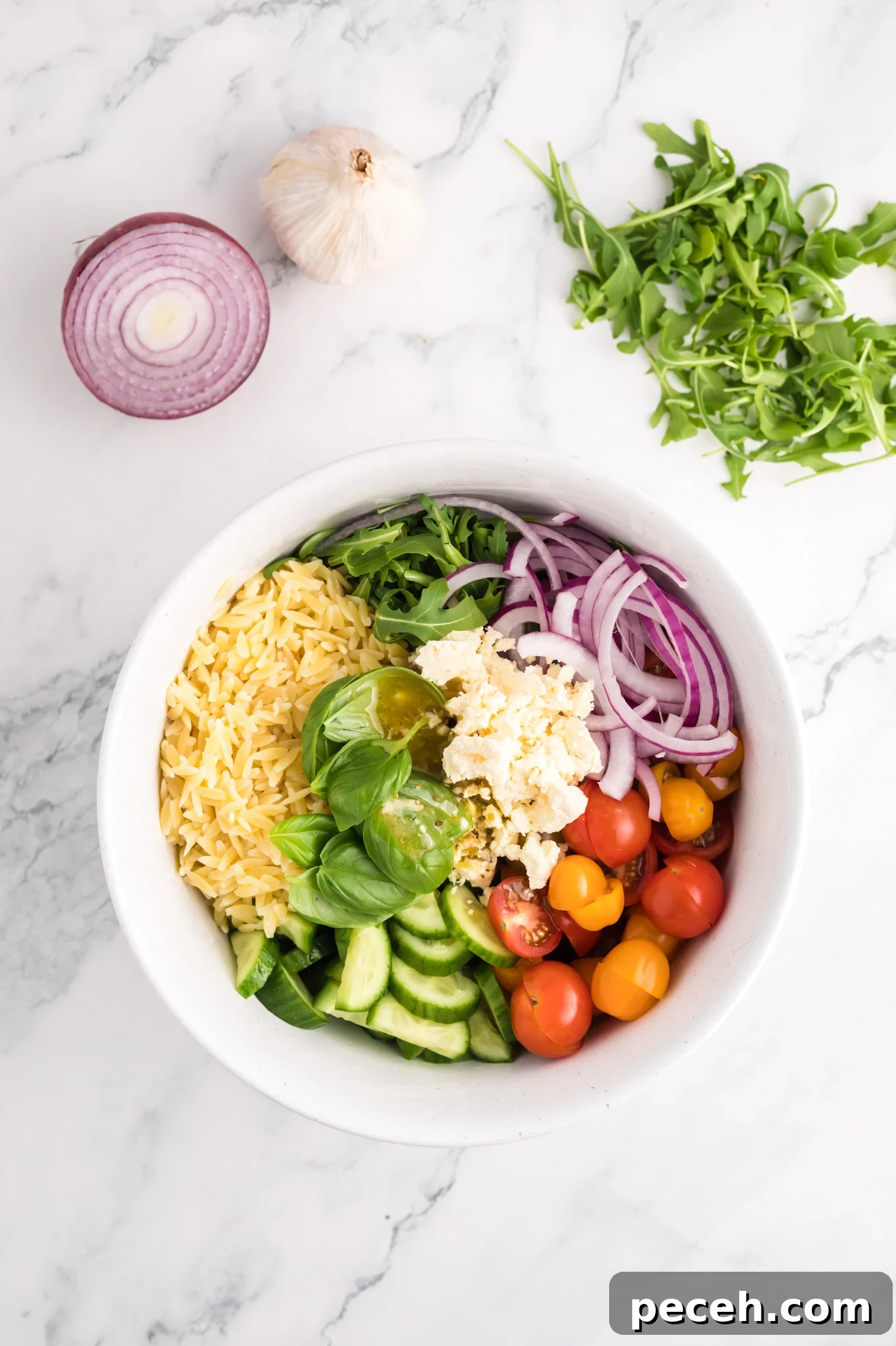 Zesty Arugula and Lemon Orzo Salad with Parmesan 9 Arugula Orzo Salad ingredients in a bowl.