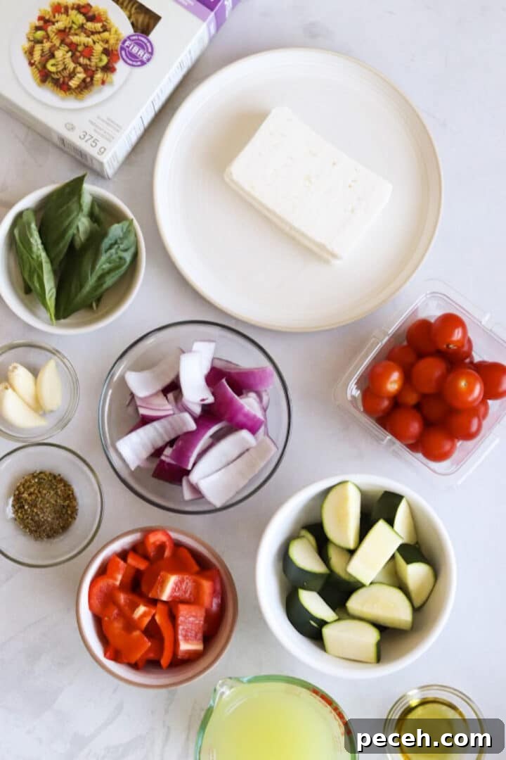 Roasted Feta Pasta with Extra Vegetables 4 Ingredients for baked feta pasta with more vegetables displayed in small bowls on a white kitchen counter
