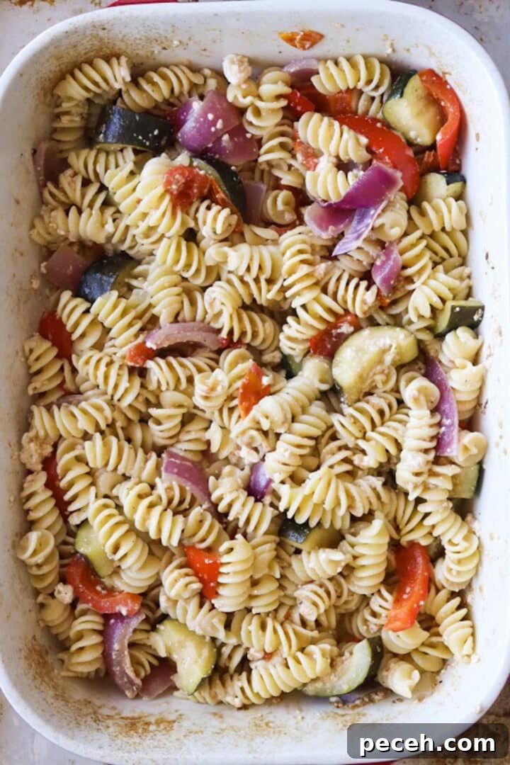 Roasted Feta Pasta with Extra Vegetables 8 Stirred baked feta pasta with extra roasted vegetables in a large baking dish
