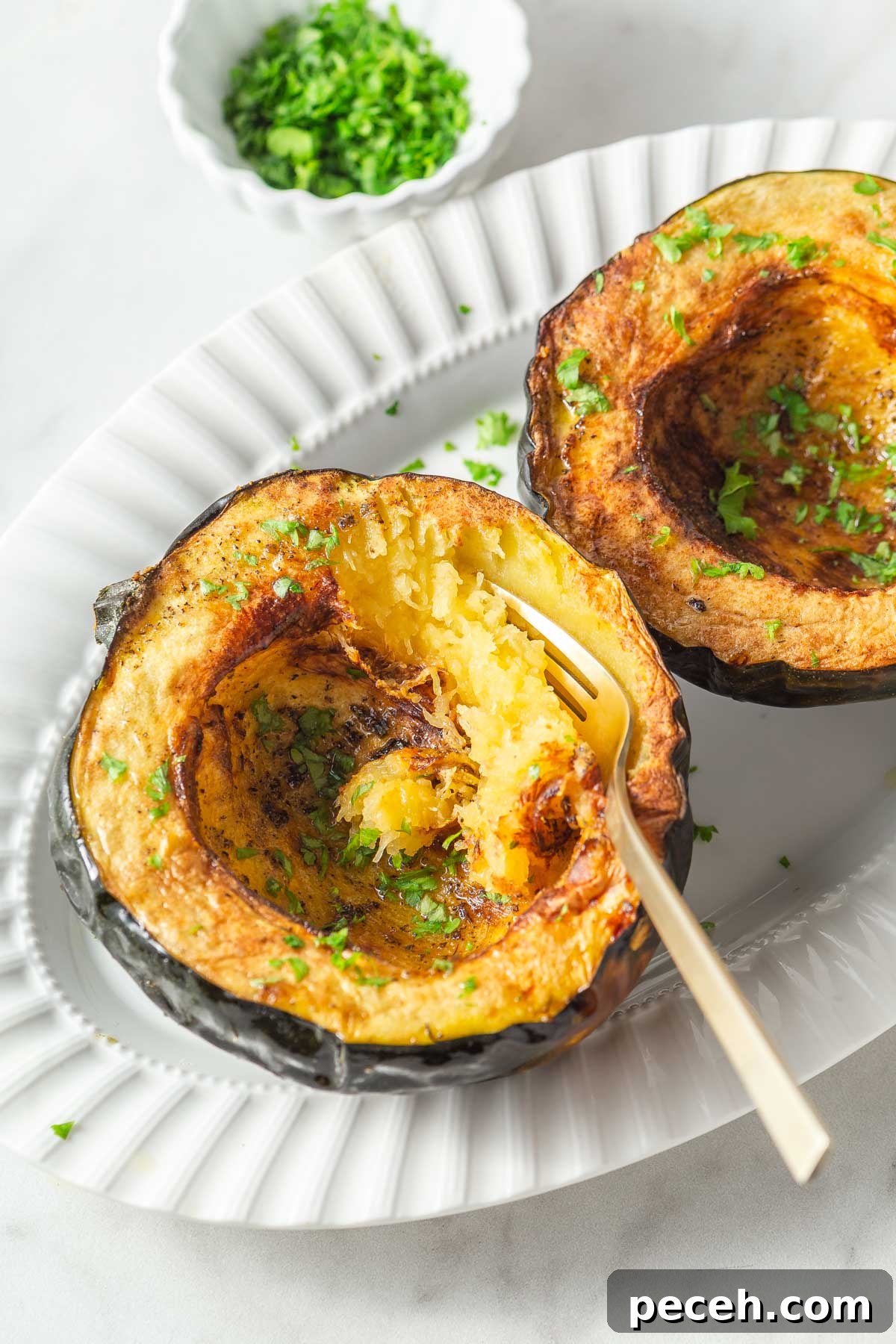 Crispy Air-Fried Acorn Squash Recipe for Fall Side Dish 2 air fryer acorn squash with parsley on a plate with a fork.