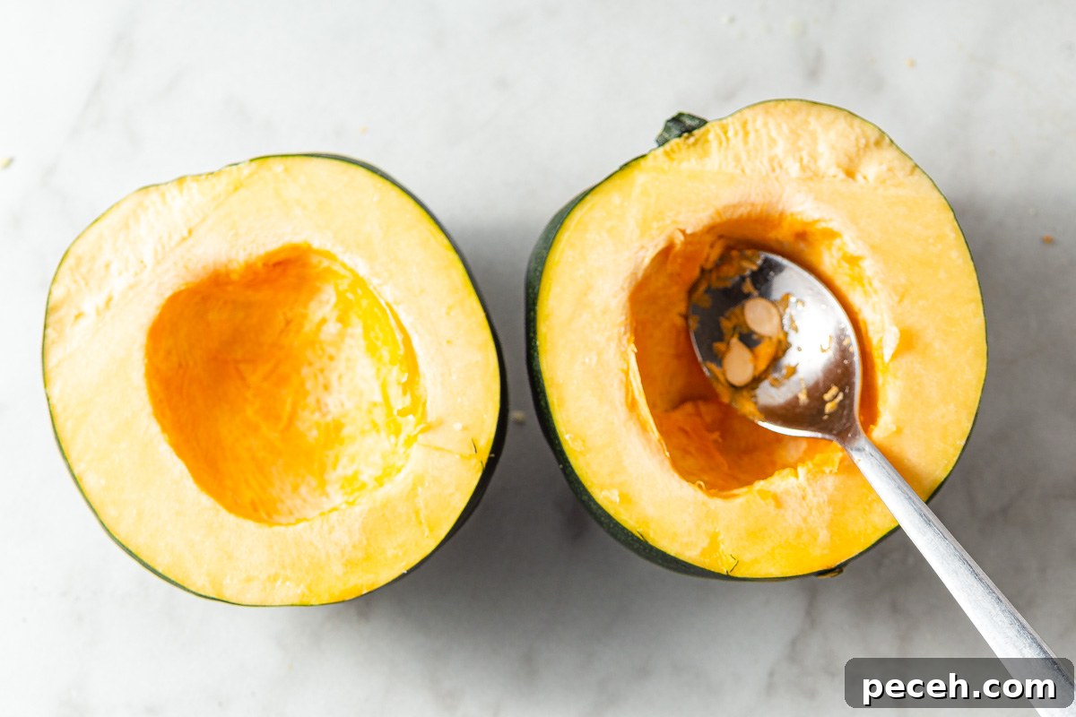 Crispy Air-Fried Acorn Squash Recipe for Fall Side Dish 5 scopping acorn squash seeds with a spoon.