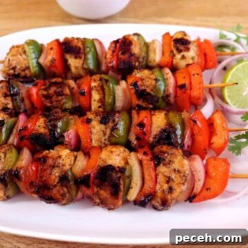 mediterranean chicken kebabs on skewers. Served with onion rings and a lemon slice.