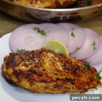 cumin chicken breast served on a white plate.